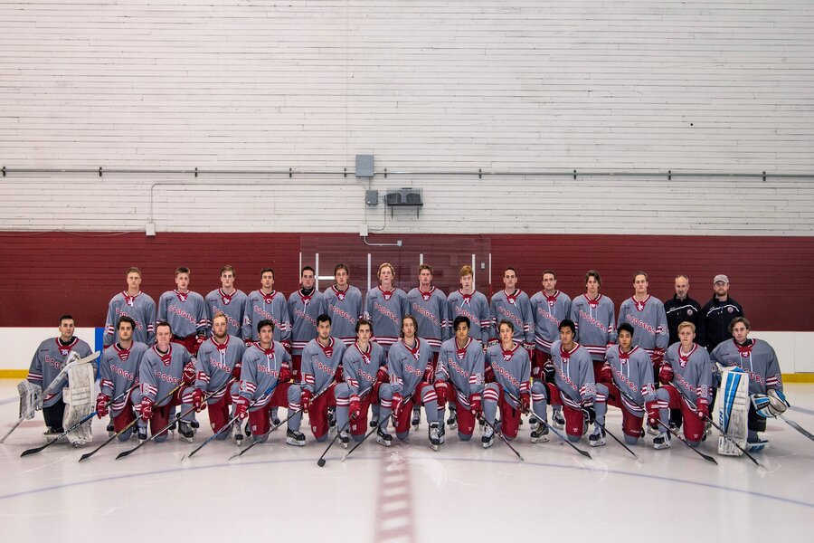 Photo of the UW Men's Ice Hockey team wearing blue and red uniforms on ice