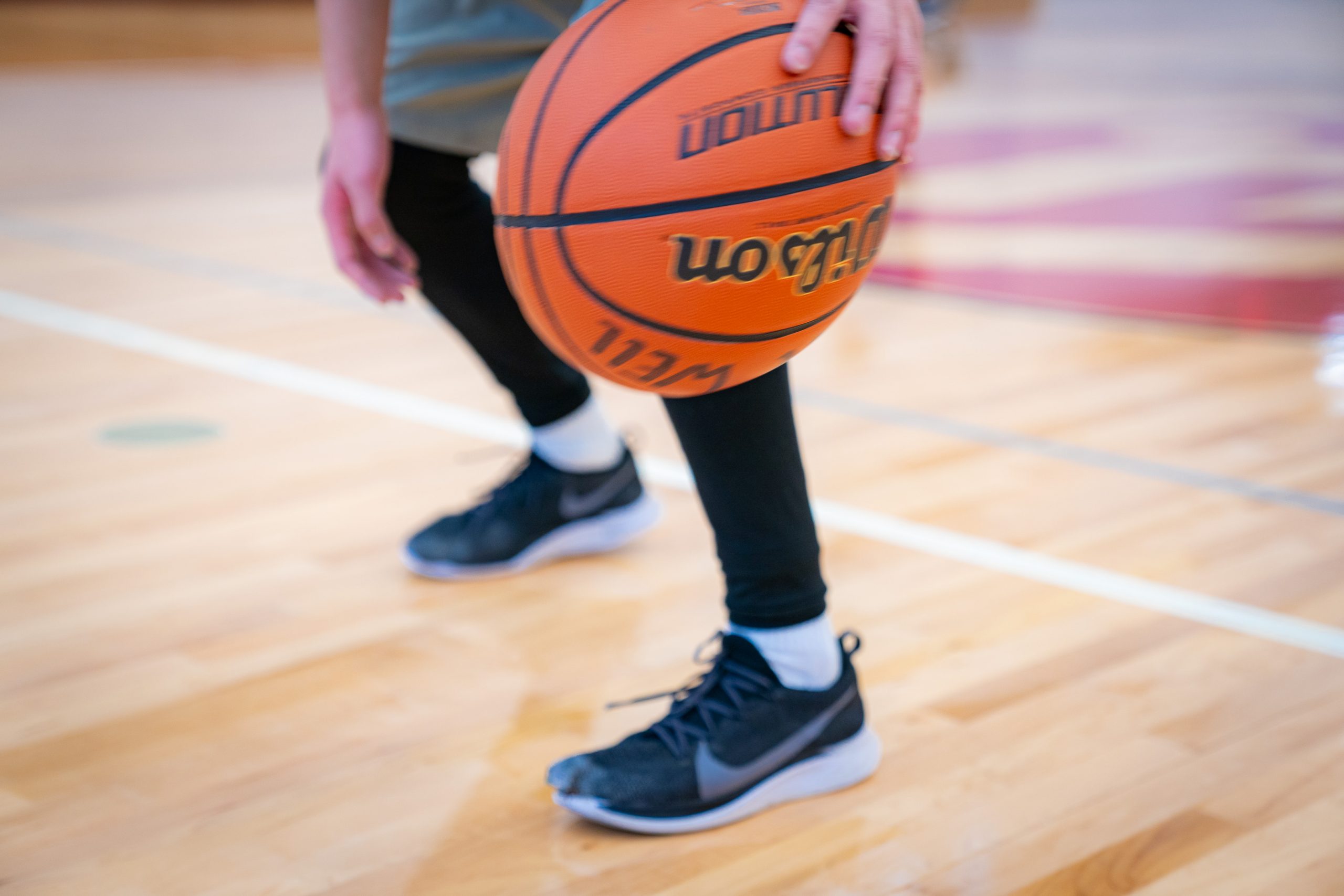 A photo of a basketball being dribbled.