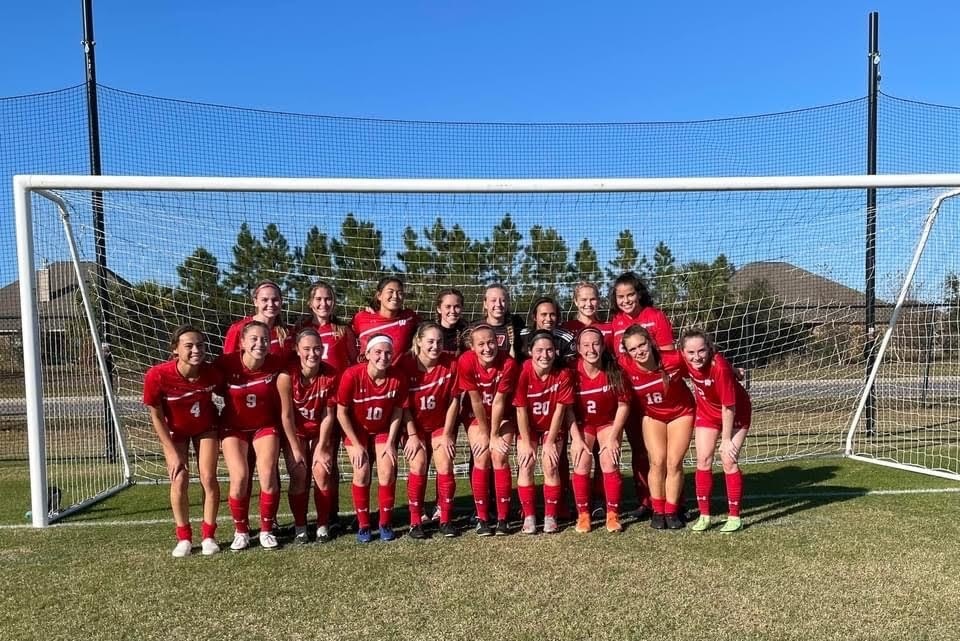 Women's club soccer team throwing up a W in their team picture