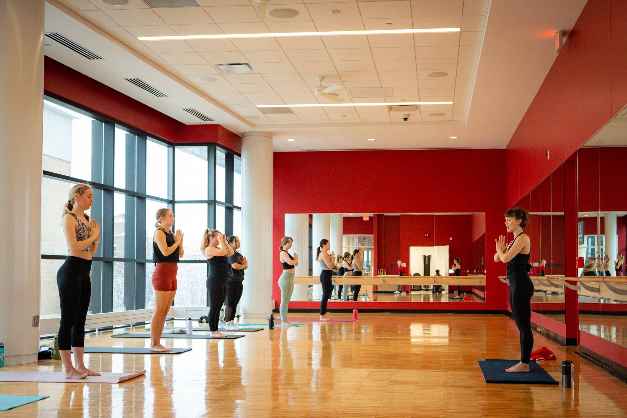 A photo of group fitness participants in a yoga class.