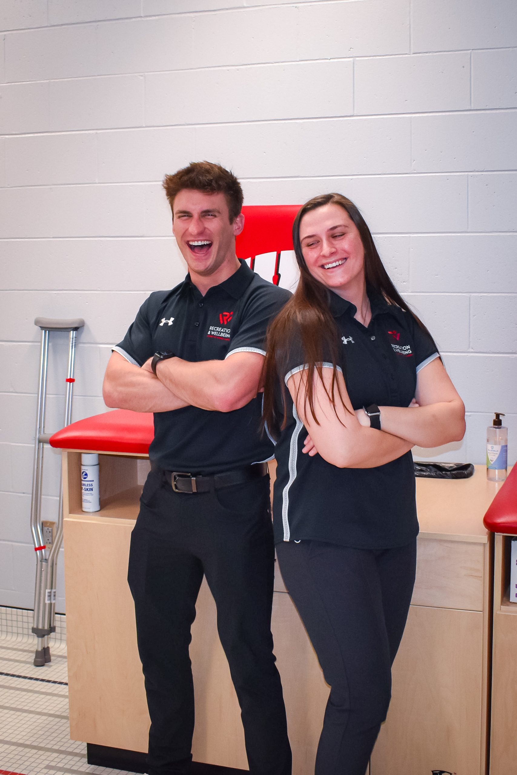 Photo of two athletic trainers standing back to back.