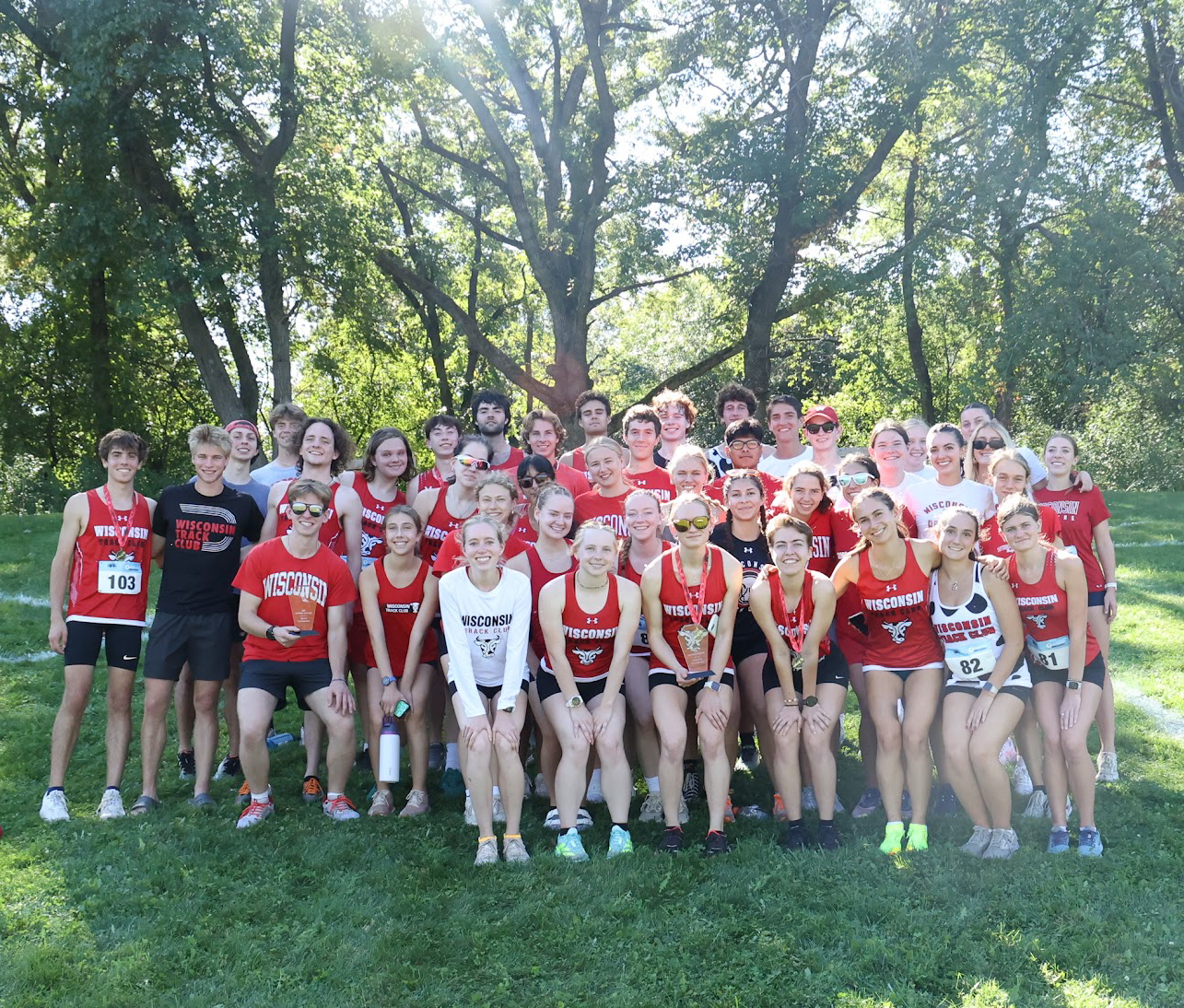 group photo of track club team on football field.