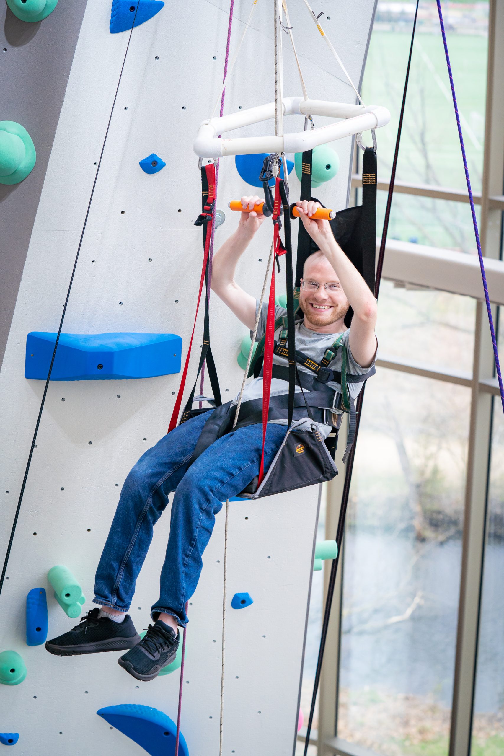 Person using the adaptive climbing option on the Mendota Climbing wall