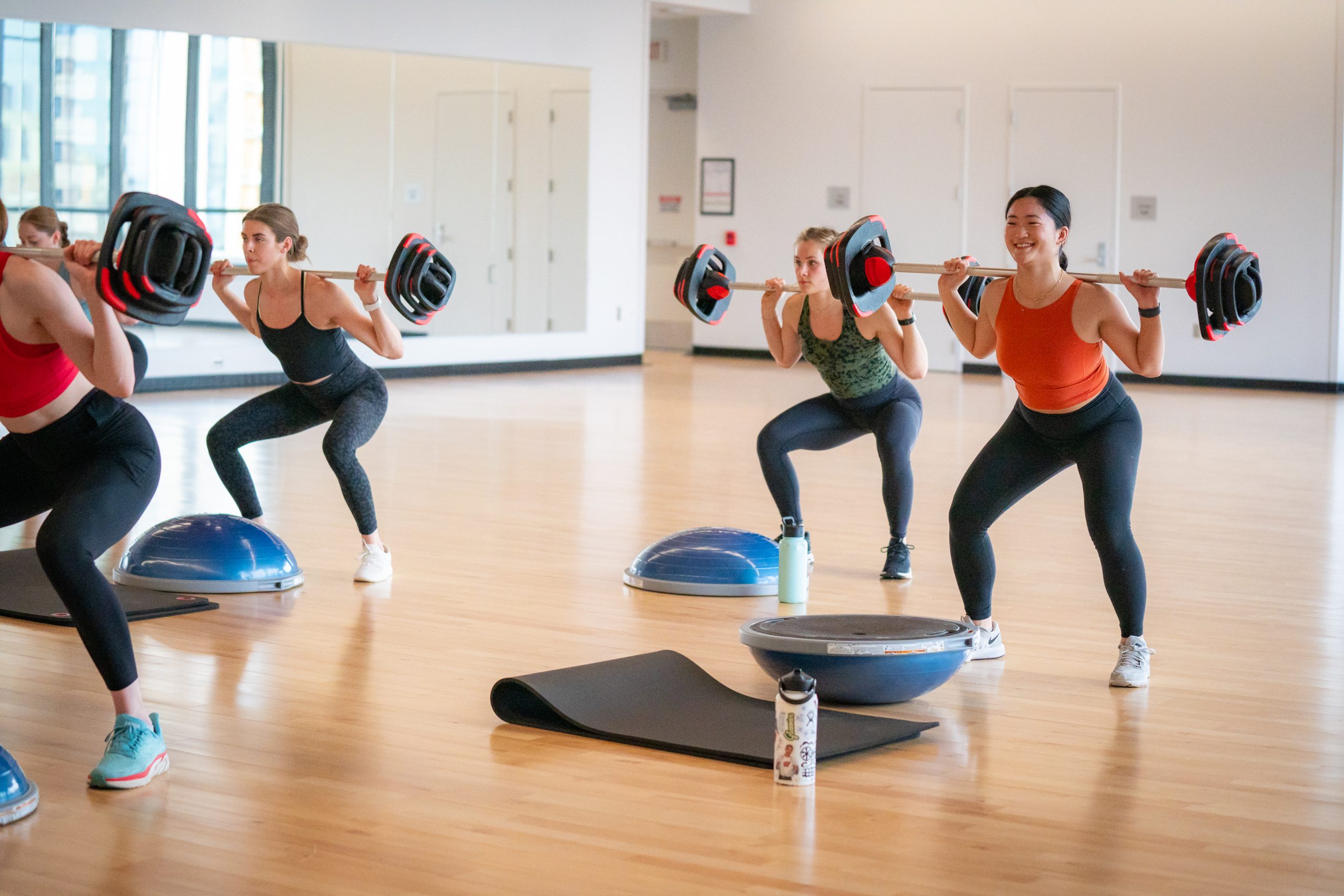 A photo of group fitness participants during a group strength class.