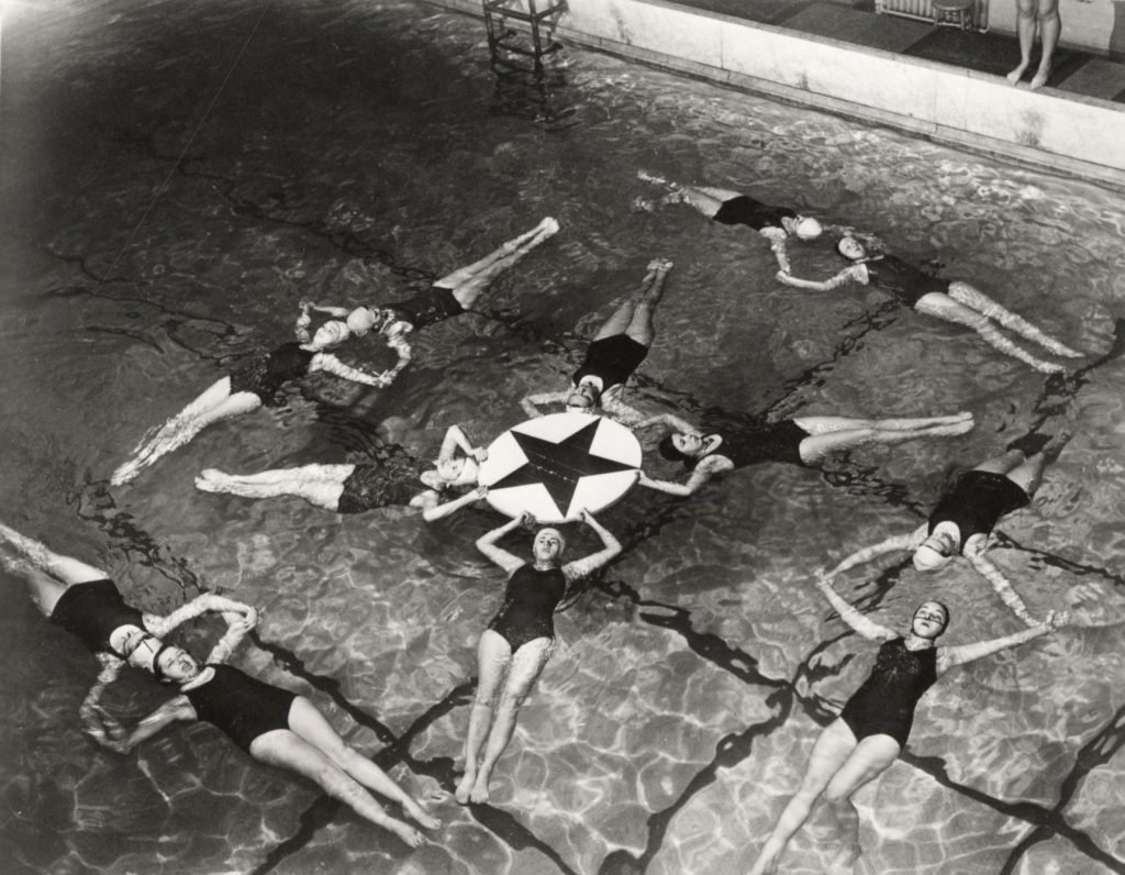 A synchronized women's swimming team practices in the pool at Lathrop Hall. ca. 1929-1939.