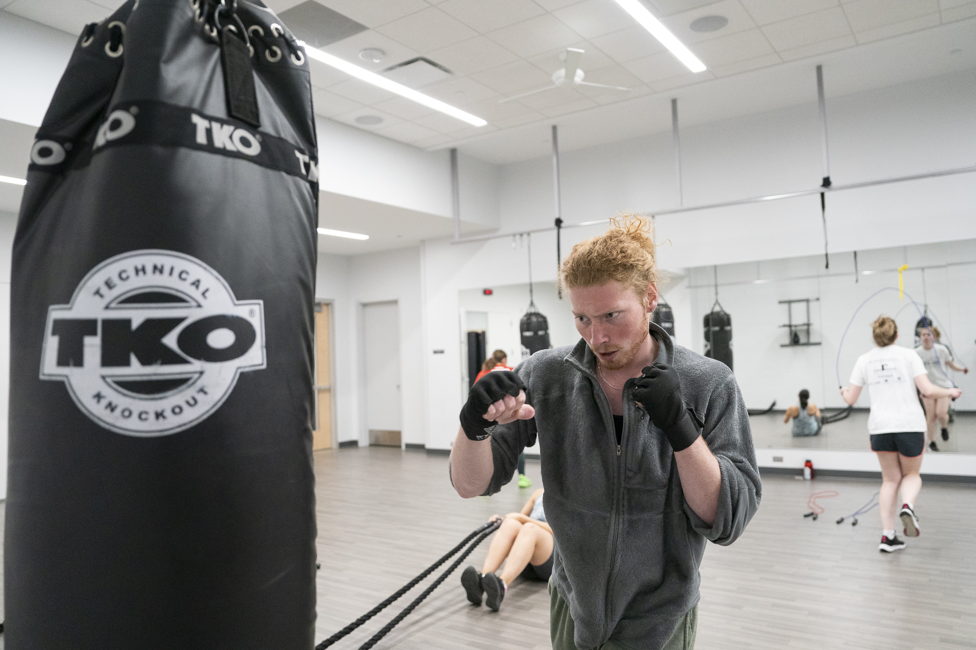 Strike360 class participant in a guarded stance preparing to punch the sand bag.