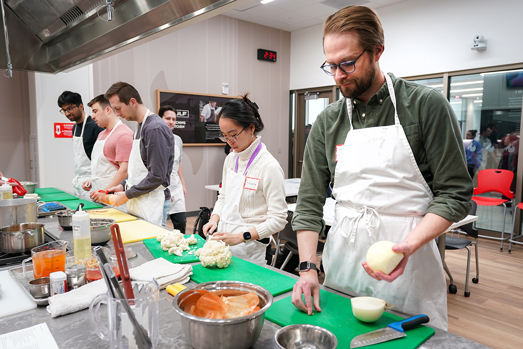A photo of people cooking in the Wolf Teaching Kitchen.