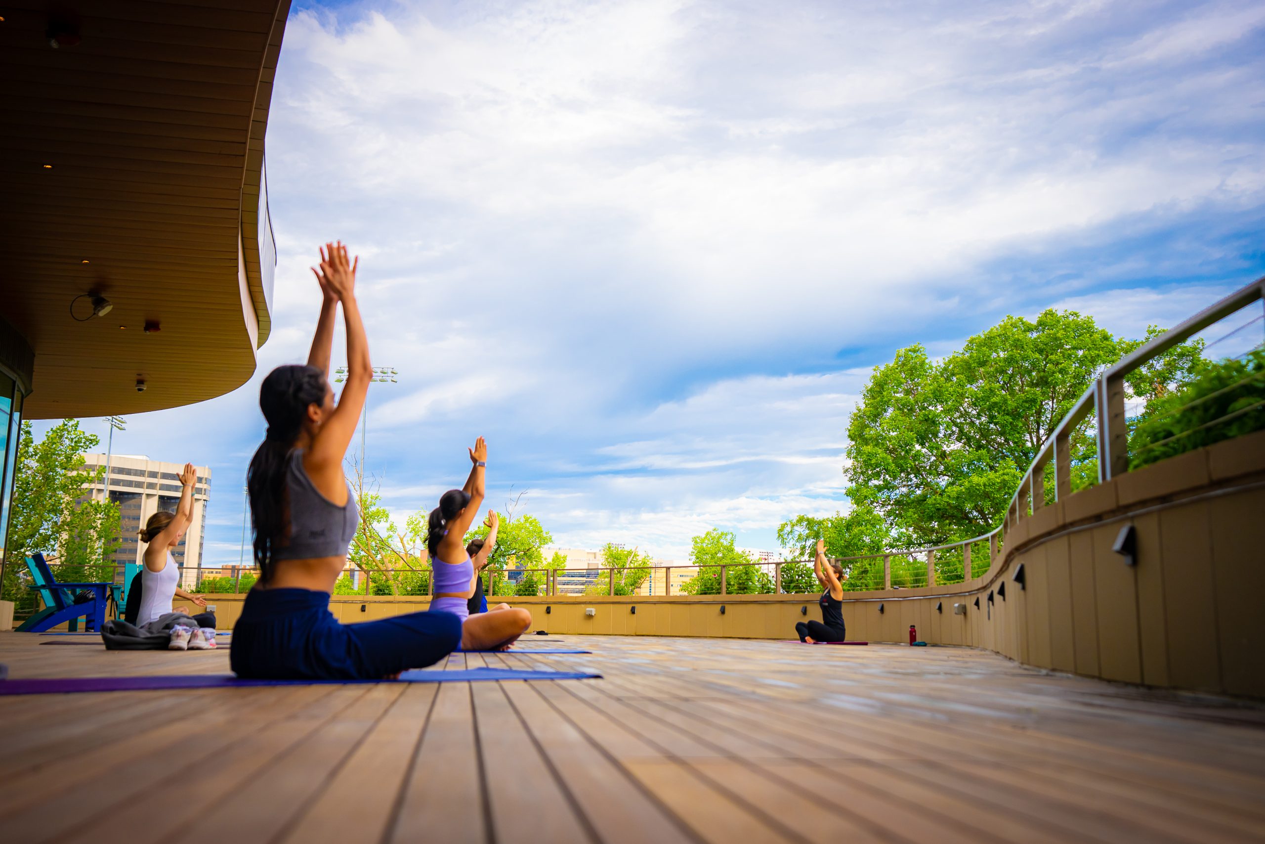 There is an image of female members doing yoga on the deck during the summer.