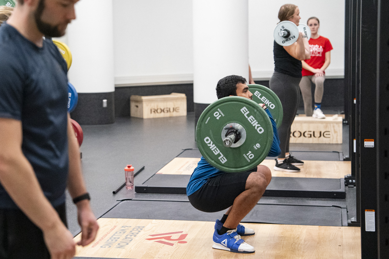 An image of two members lifting inside the Bakke Recreation & Wellbeing Center. 
