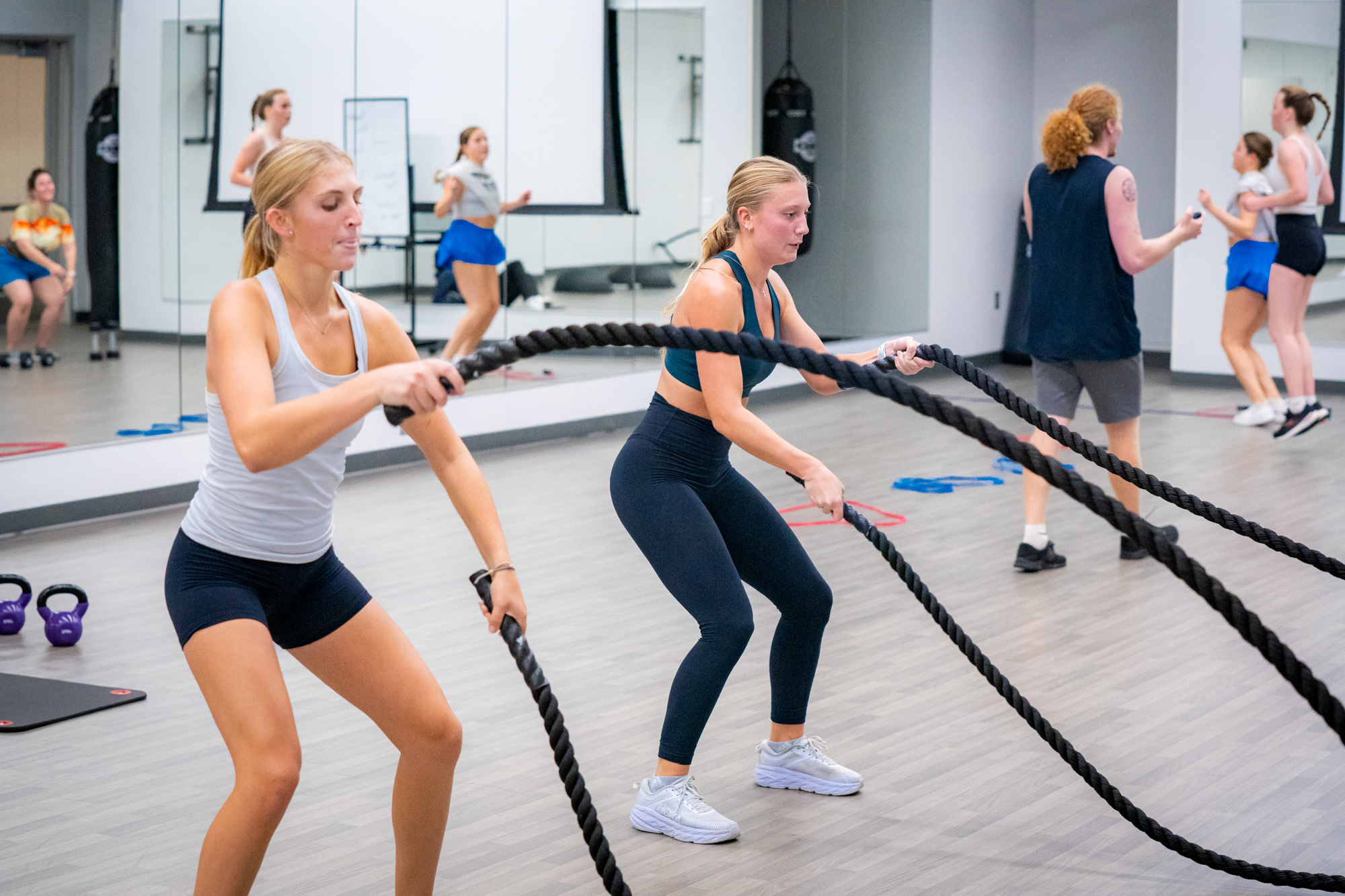 Students are pictured in a fitness studio using equipment.