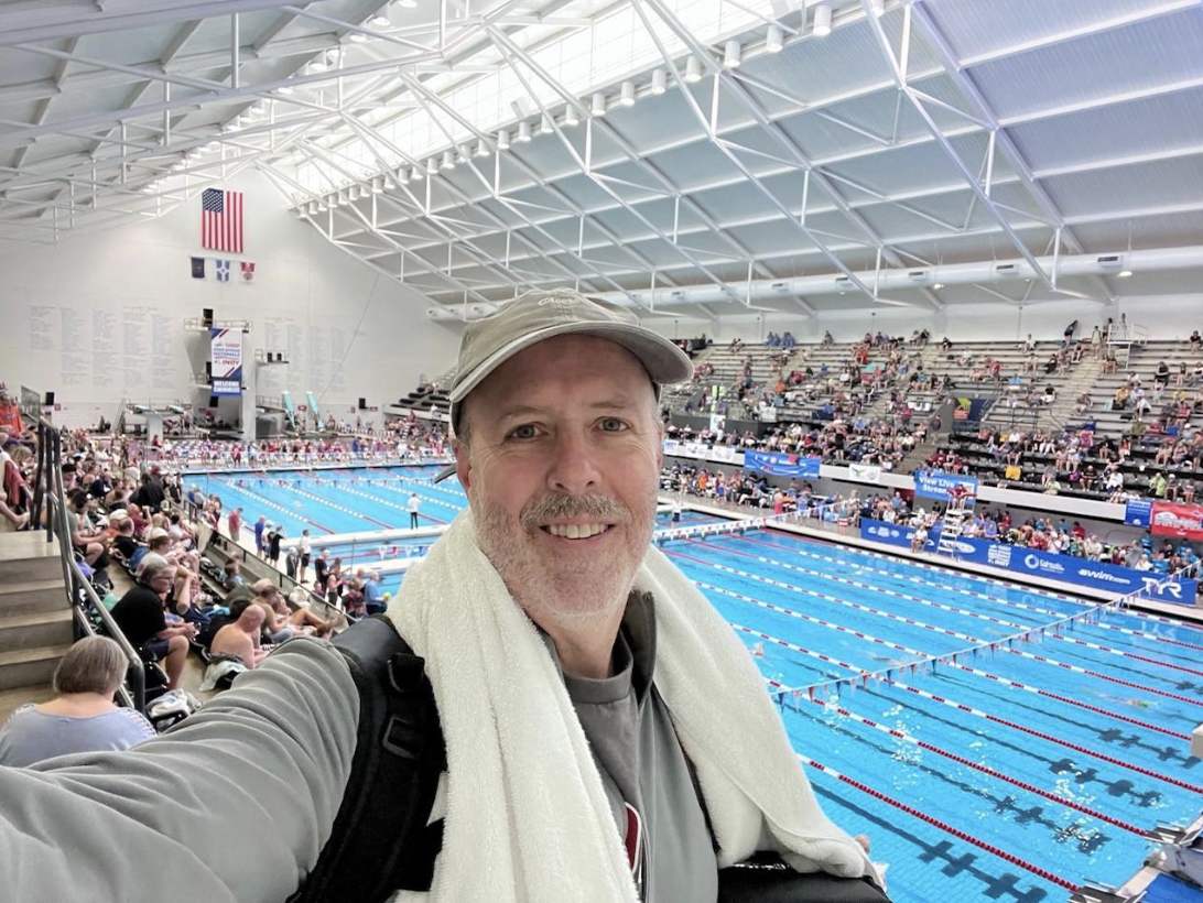 Person taking a selfie with a pool in the back.