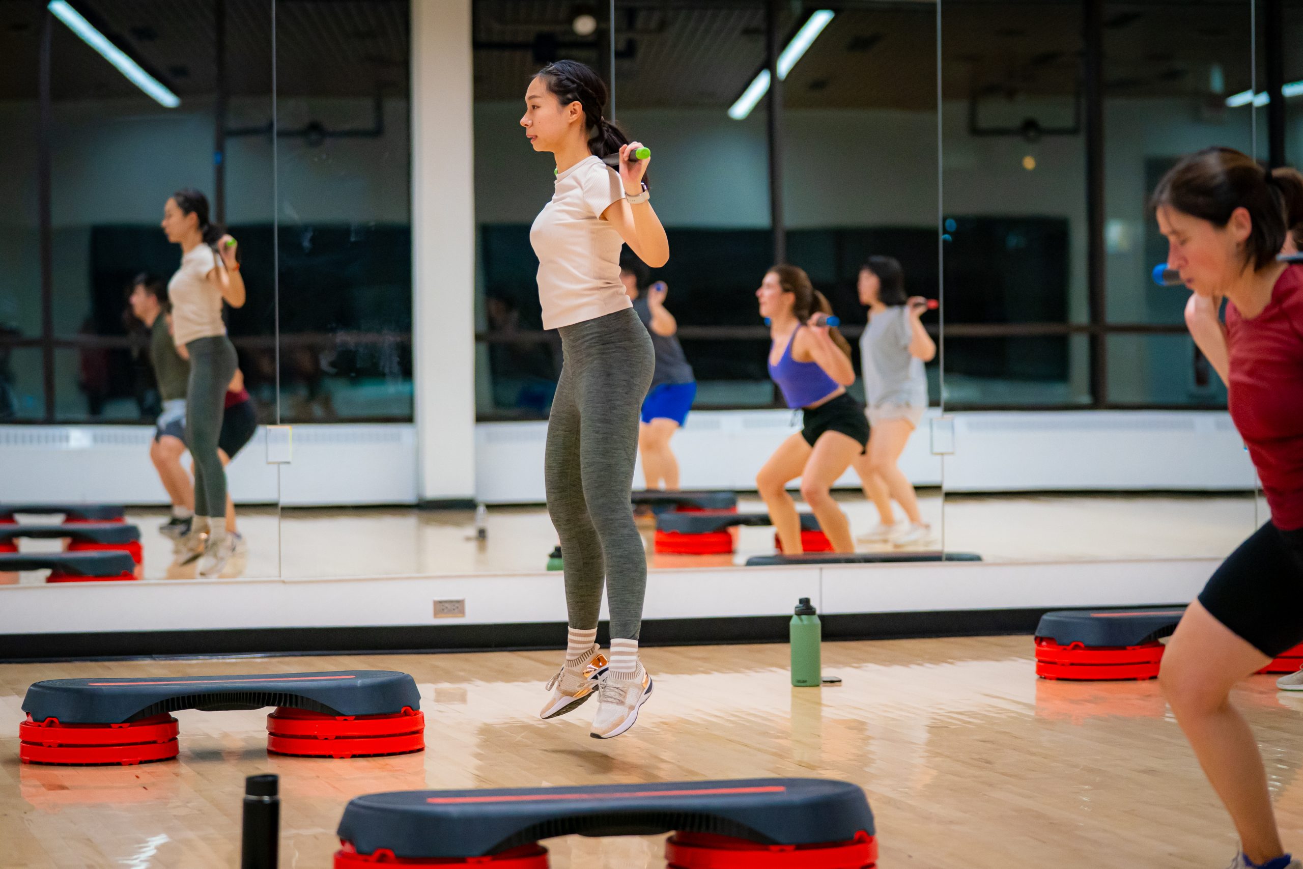 Members participate in a high intensity intervals class in a room with mirrored walls.