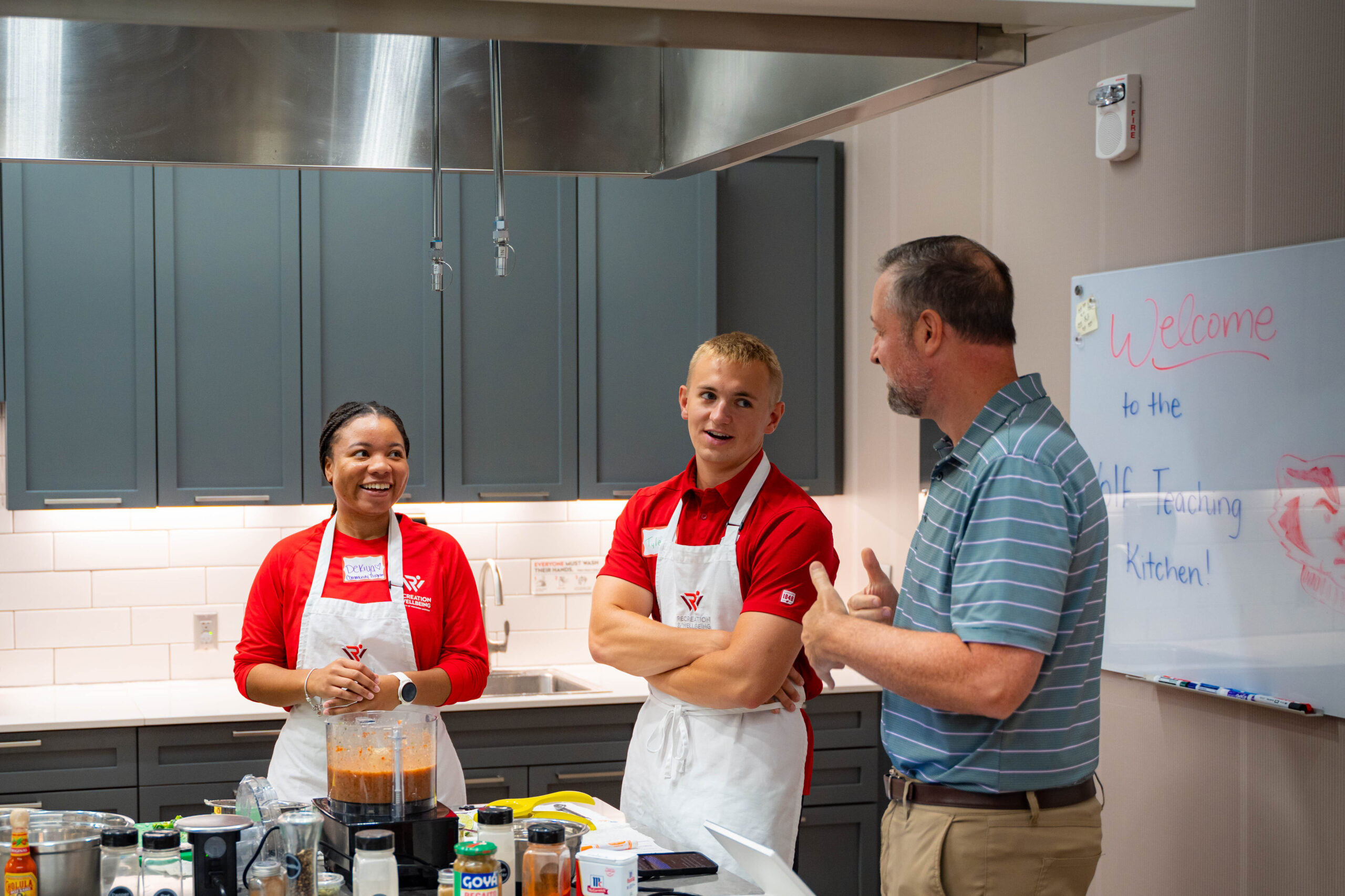 Students with aprons in the Teaching Kitchen at Bakke Recreation & Wellbeing Center