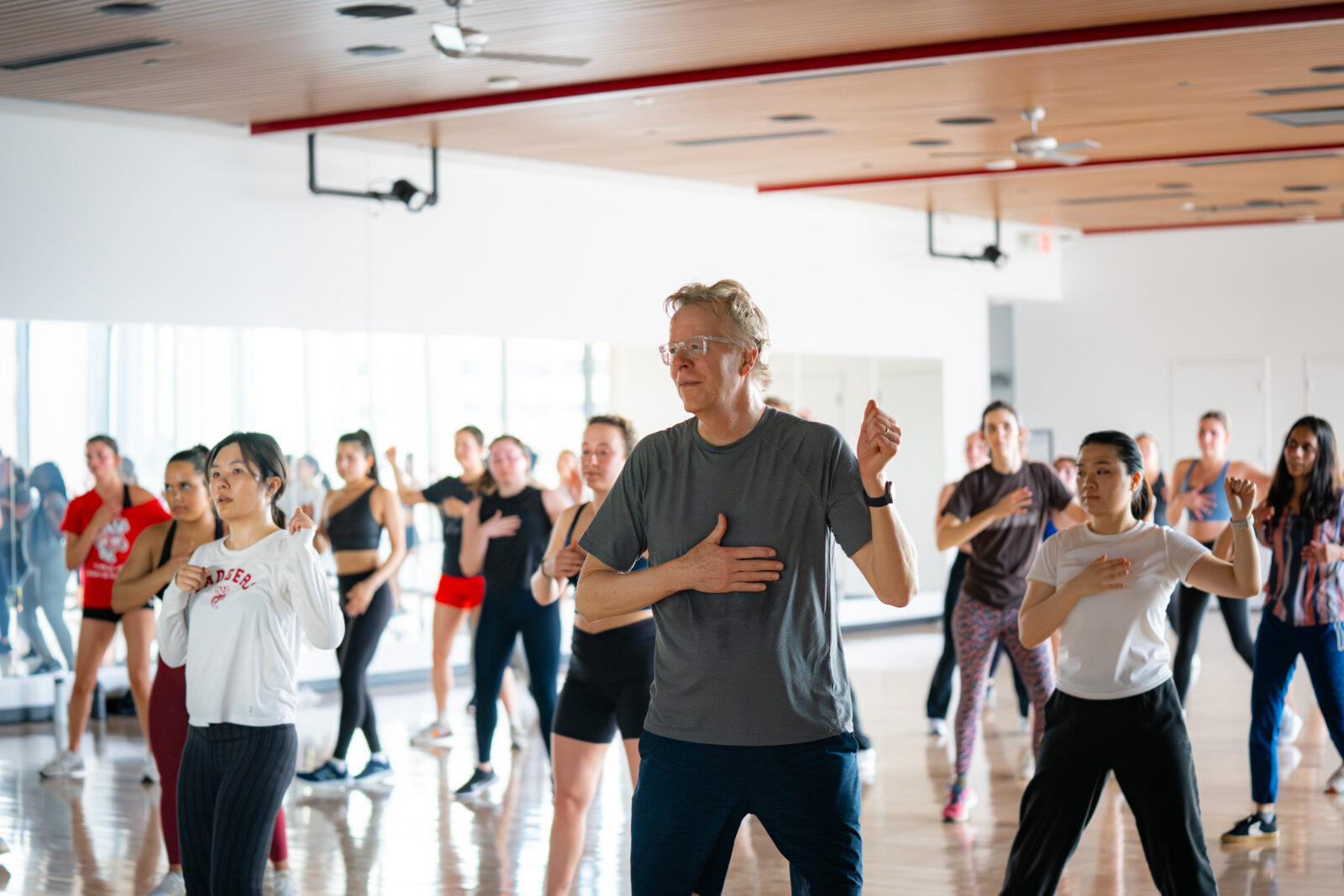 A middle aged man dancing during a Zumba class.